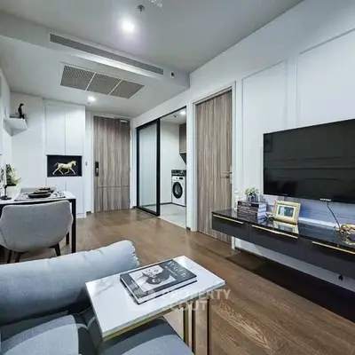 Modern living room with sleek furniture and open layout, featuring a stylish TV setup and elegant decor.