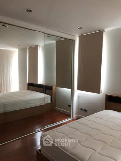 Spacious bedroom with mirrored wardrobe and natural light