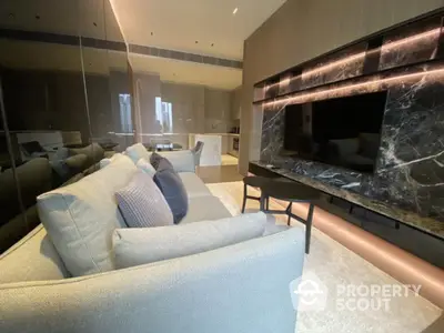 Luxurious modern living room with sleek design and large TV, perfect for relaxation and entertainment.