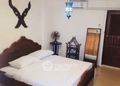 Charming bedroom with vintage decor and elegant wooden bed frame, perfect for cozy living.