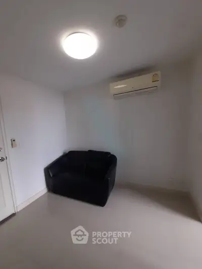 Cozy small room with air conditioning and a black sofa, perfect for a compact living space.