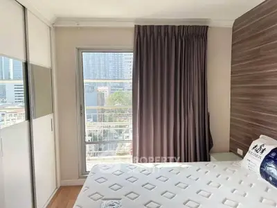 Bright bedroom with city view, featuring a large window and modern decor.