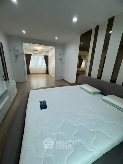 Spacious modern bedroom with elegant decor and ample natural light