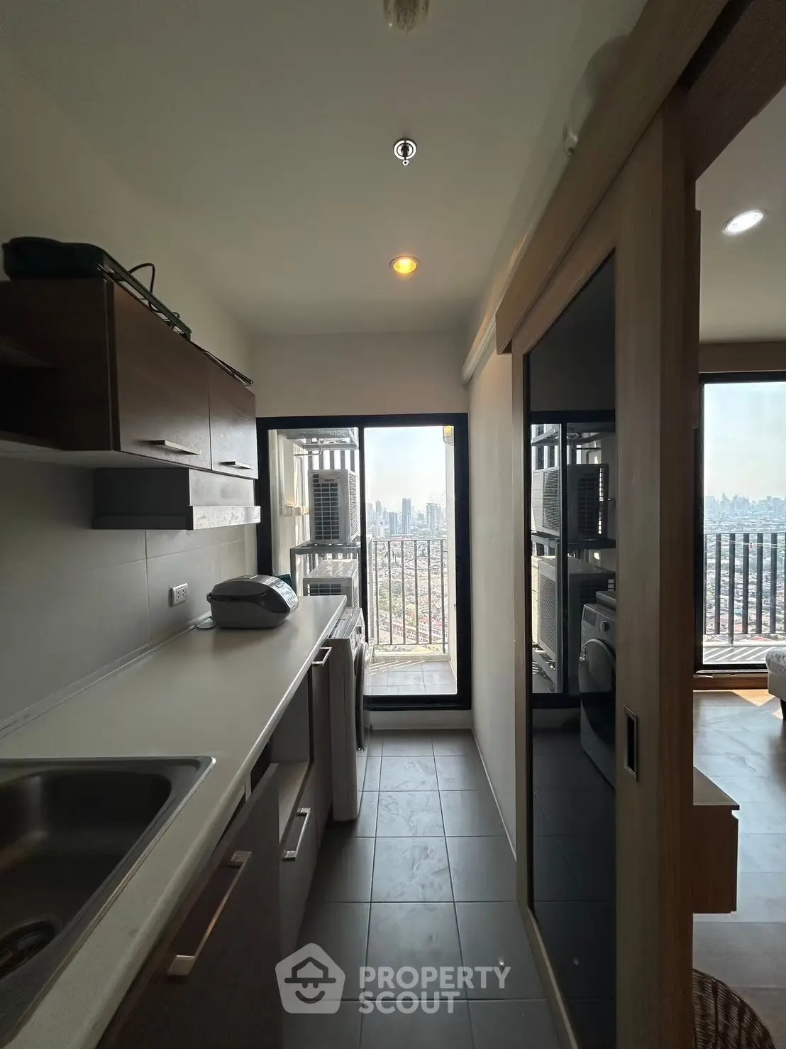 Modern kitchen with city view and sleek appliances in high-rise apartment