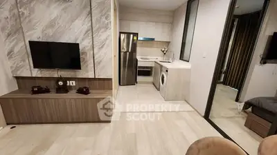 Modern open-plan living room with integrated kitchen featuring sleek appliances and stylish decor.