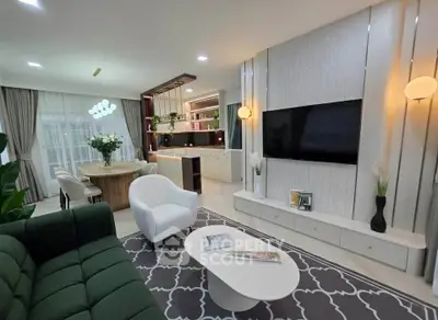 Modern living room with elegant decor, open kitchen layout, and stylish furniture.