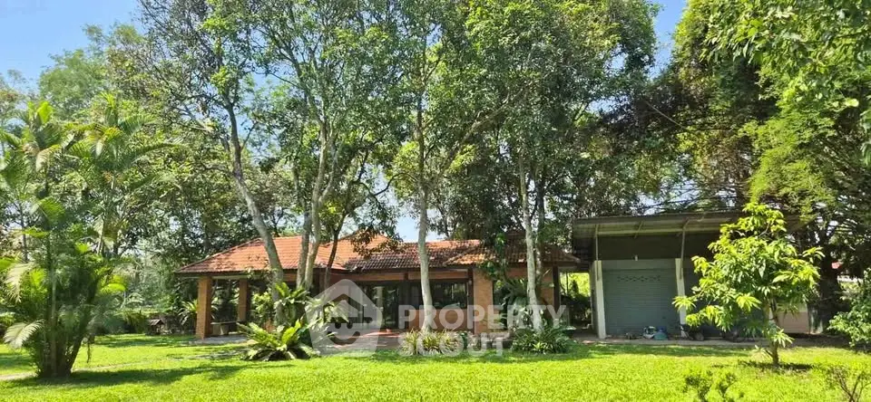Charming countryside house surrounded by lush greenery and mature trees, offering serene natural views.