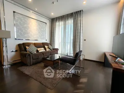 Elegant living room with modern furniture and large window, perfect for relaxation.