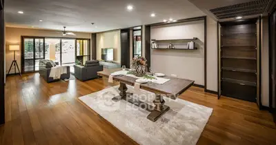 Spacious open-plan living and dining area with elegant wooden flooring and modern decor.