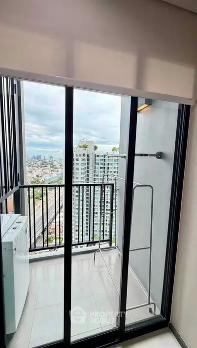 Modern high-rise balcony with city view and laundry area