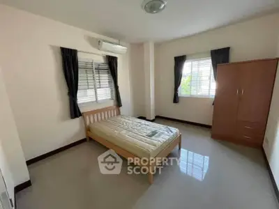 Spacious bedroom with natural light, featuring a bed and wardrobe, ideal for comfortable living.