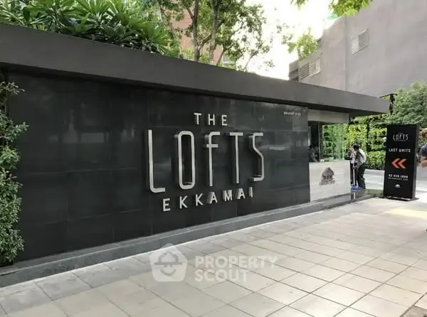 Modern entrance of The Lofts Ekkamai with sleek design and lush greenery.