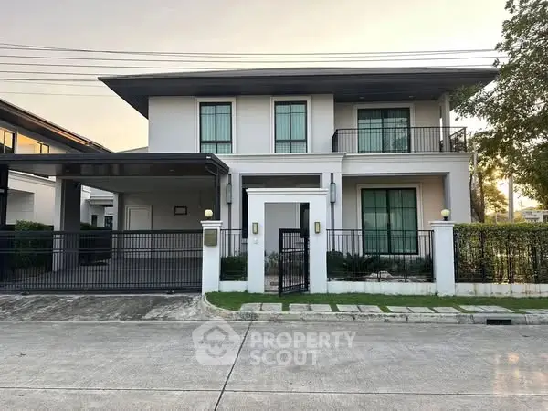 Modern two-story house with sleek design and spacious driveway in a serene neighborhood.