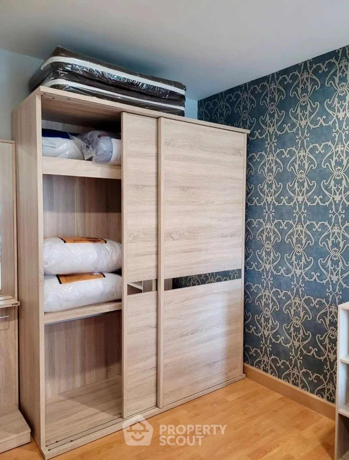 Spacious bedroom with elegant wardrobe and stylish wallpaper, perfect for modern living.