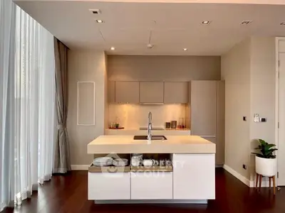 Modern kitchen with sleek island and elegant lighting in a luxury apartment.
