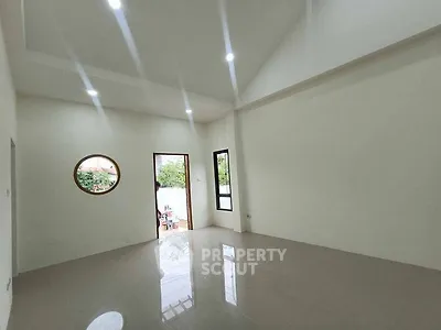 Spacious empty room with modern lighting and unique round window
