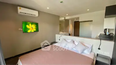 Modern bedroom with wall-mounted TV and air conditioning in a stylish apartment.