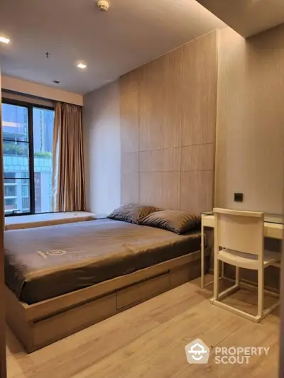 Modern bedroom with wooden flooring and large window in luxury apartment