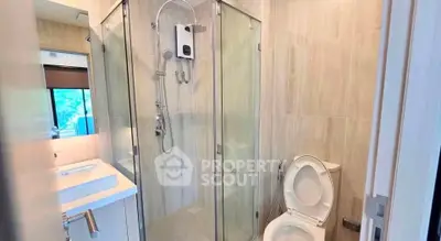 Modern bathroom with glass shower and sleek fixtures in a contemporary home.