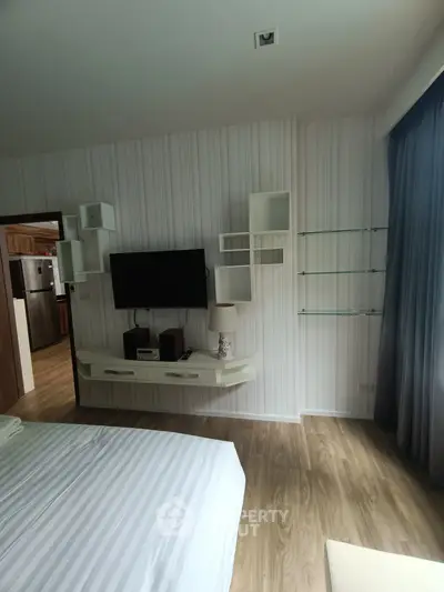 Modern bedroom with wall-mounted TV and stylish shelving