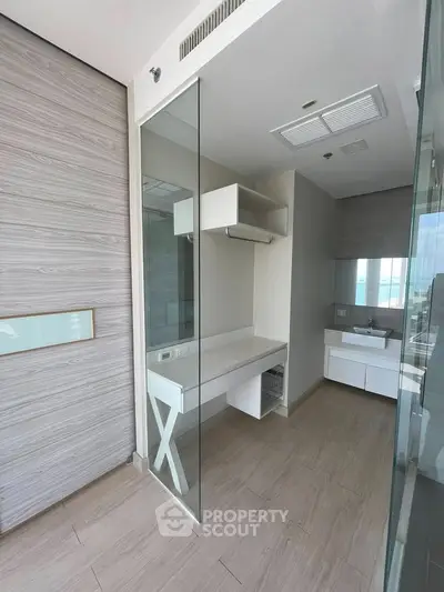 Modern bathroom with glass partitions and sleek vanity in luxury apartment