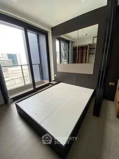Modern bedroom with large window and city view, featuring sleek design and ample natural light.