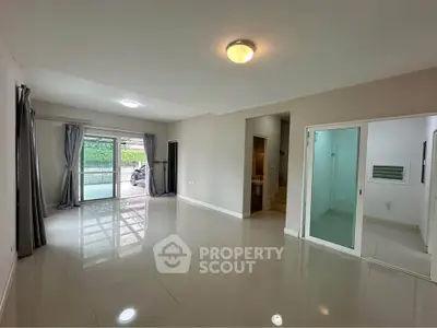 Spacious modern living room with large windows and sliding glass doors opening to a patio.