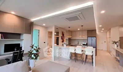 Modern open-plan living room and kitchen with sleek design and natural light