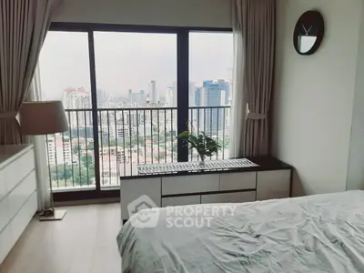Modern bedroom with stunning city view from large window, featuring elegant decor and natural light.