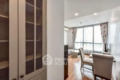 Bright living room with elegant furniture and large window, featuring hardwood floors and modern decor.
