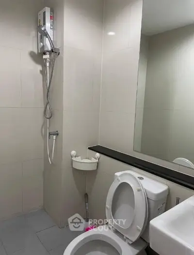 Modern bathroom with shower and toilet in a sleek, minimalist design.