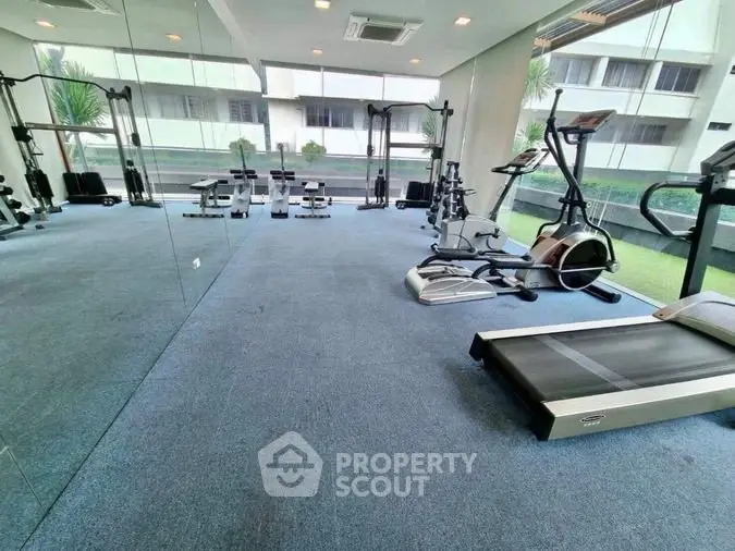 Spacious modern gym with state-of-the-art fitness equipment and large windows.