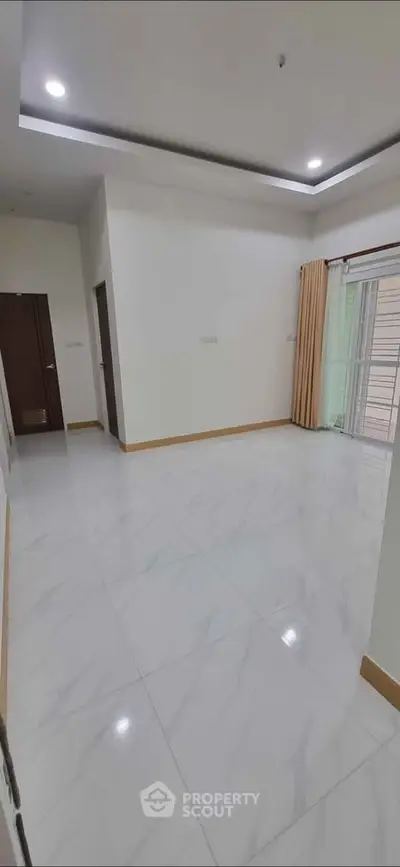 Spacious empty living room with marble flooring and large windows