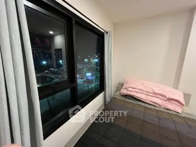Cozy bedroom with large window offering stunning night city view