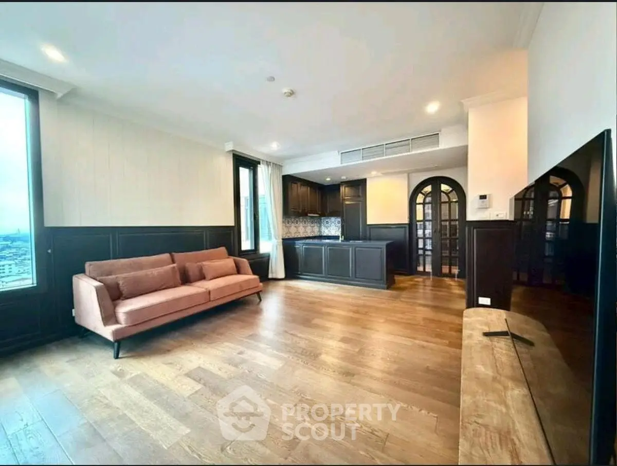 Spacious living room with elegant wooden flooring and modern open kitchen design.