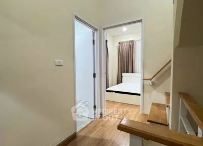 Cozy interior hallway leading to a bedroom with wooden flooring and modern design.