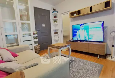 Cozy living room with modern decor and large TV, perfect for relaxation.