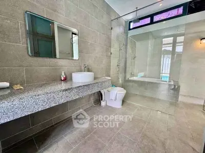 Spacious modern bathroom with glass shower and sleek fixtures in luxury home.