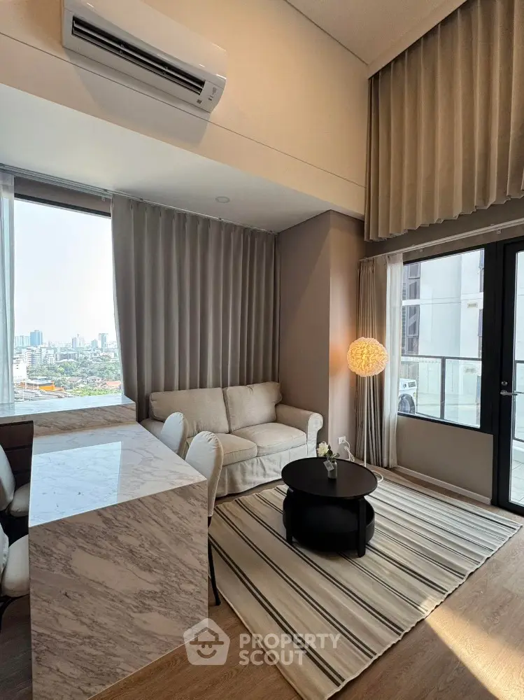 Modern living room with city view, featuring elegant decor and natural light.