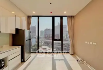 Modern kitchen with large windows and city view, featuring sleek cabinetry and stainless steel appliances.