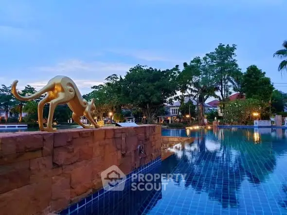 Luxurious outdoor pool with artistic sculpture and serene garden view at twilight.