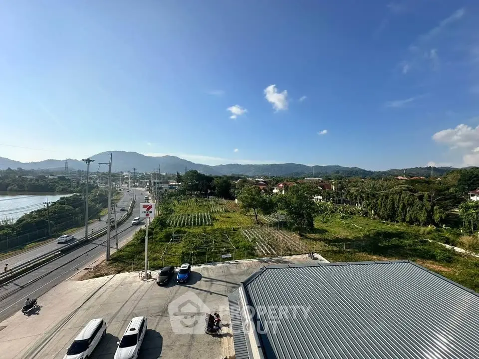 Scenic view of lush green landscape and distant mountains from a rooftop perspective.
