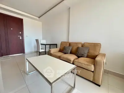 Modern living room with beige sofa and sleek coffee table in a bright apartment.