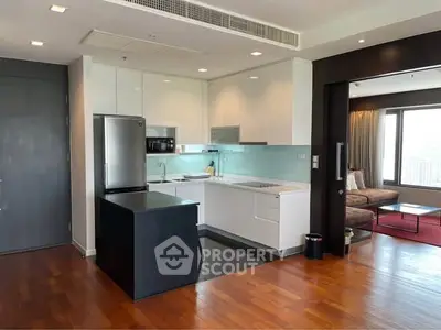 Modern open-layout kitchen with sleek appliances and adjacent cozy living area.