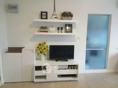 Modern living room with stylish shelving and TV unit, featuring elegant decor and sunflowers for a cozy ambiance.