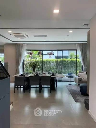 Luxurious open-plan living and dining area with large windows and modern decor.