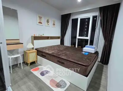 Modern bedroom with stylish decor and large window offering city views.