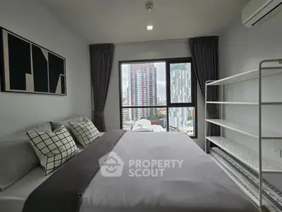 Modern bedroom with city view, featuring stylish decor and ample natural light.
