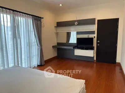 Spacious bedroom with modern decor and large windows for natural light