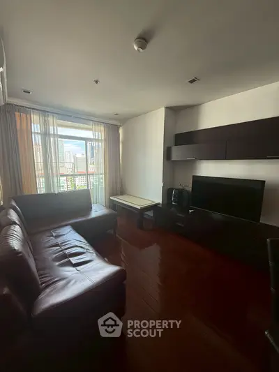 Spacious living room with leather sofa and city view, perfect for modern urban living.